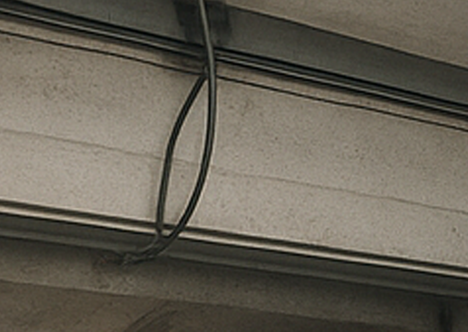 Garage door professional inspecting pulley system for cable alignment and wear